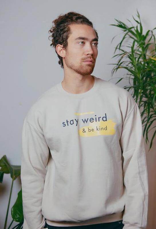 Man in Scoria sweatshirts that say Stay Weird and Be Kind